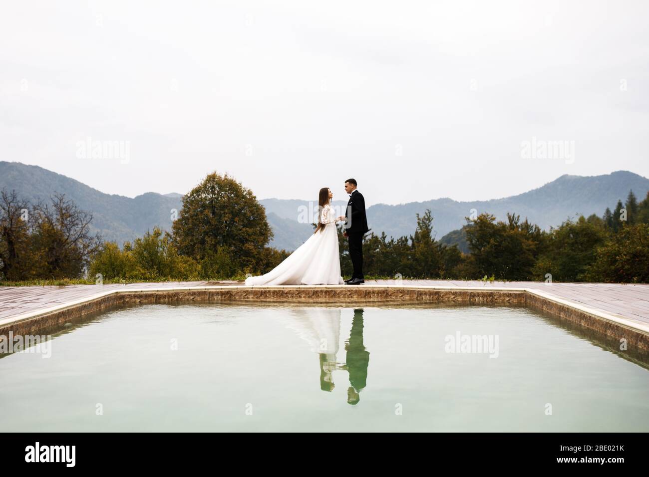 Anniversaire de mariage jeunes gens sympathiques. Jeune couple amoureux. Une histoire d'amour près de la piscine. Banque D'Images