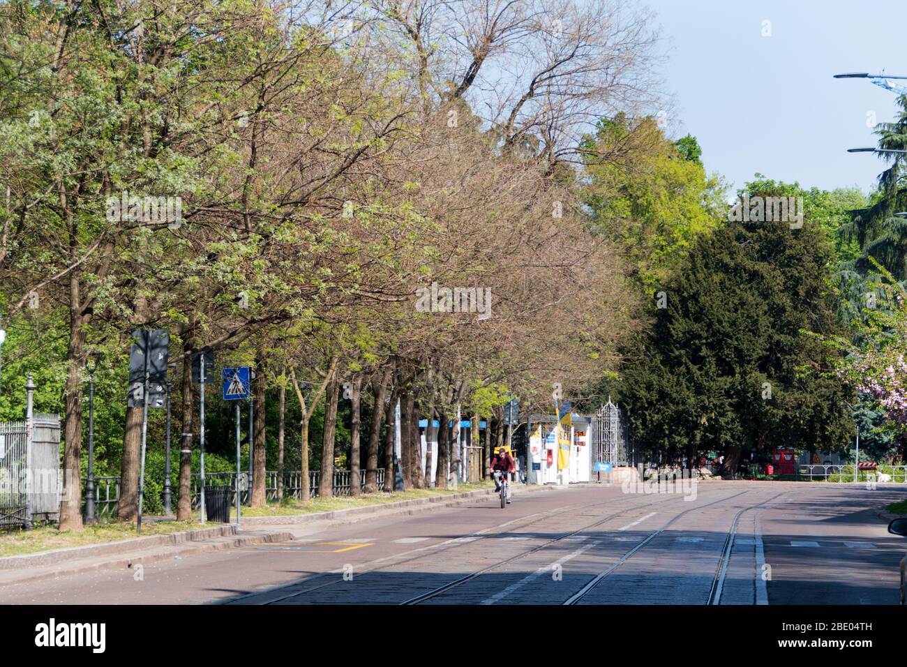 Homme à vélo pour la livraison à domicile sur route vide sans circulation à Milan, Italie en COVID-19 pandémie: Via Palestro. Milano, Coronavirus de la ville italienne Banque D'Images