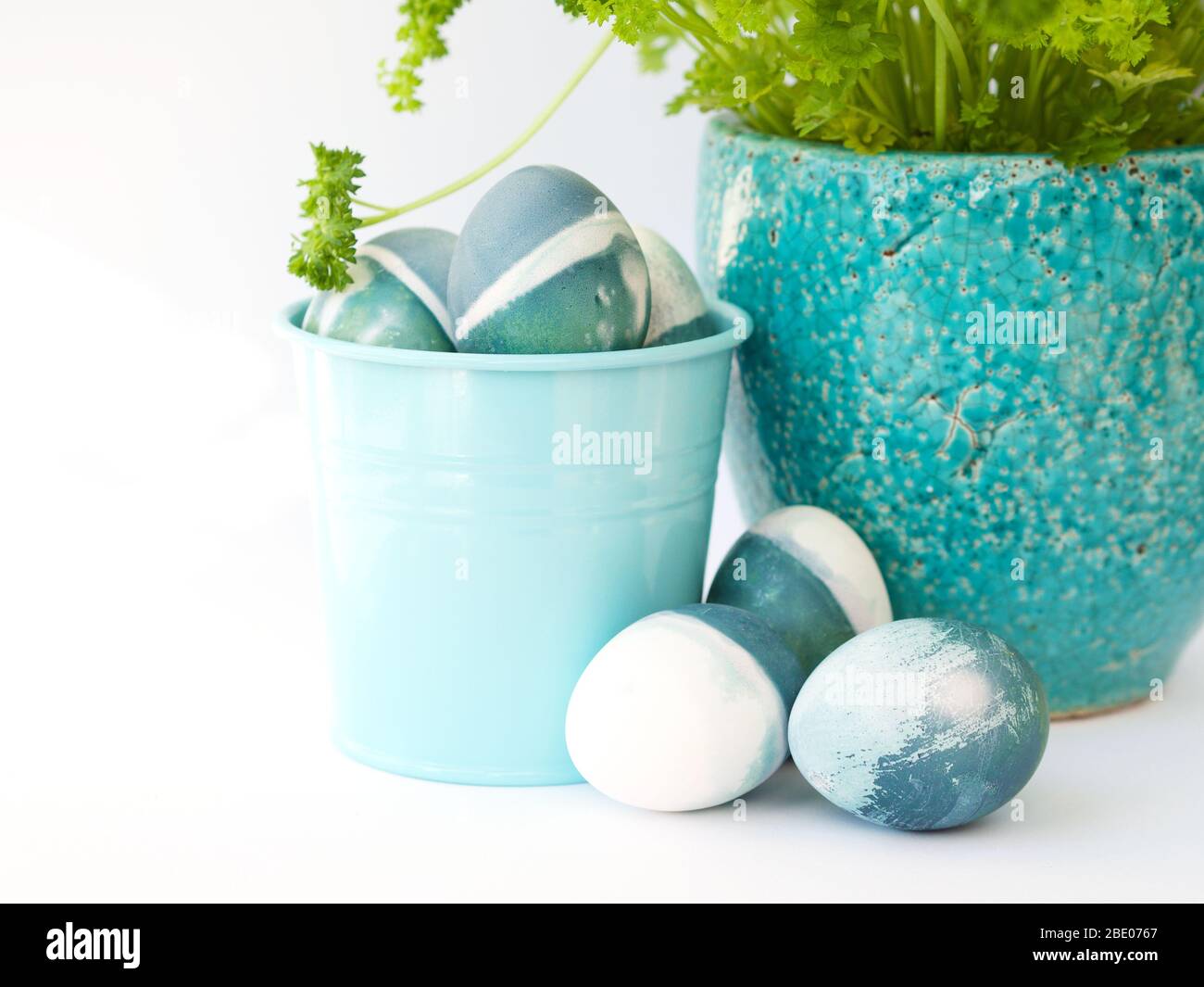 Bleu, vert, turquoise et blanc œufs de pâques faits maison de couleur rouge chou naturel sur fond blanc avec espace vide décoré. Banque D'Images