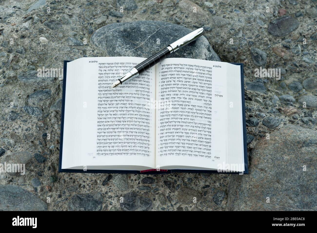 Bible hébraïque ouverte - TANAKH (Torah, Neviim, Ketuvim - la Loi, les prophètes, les écrits) avec plume de fontaine plein air. Isolé sur fond de pierres. Banque D'Images