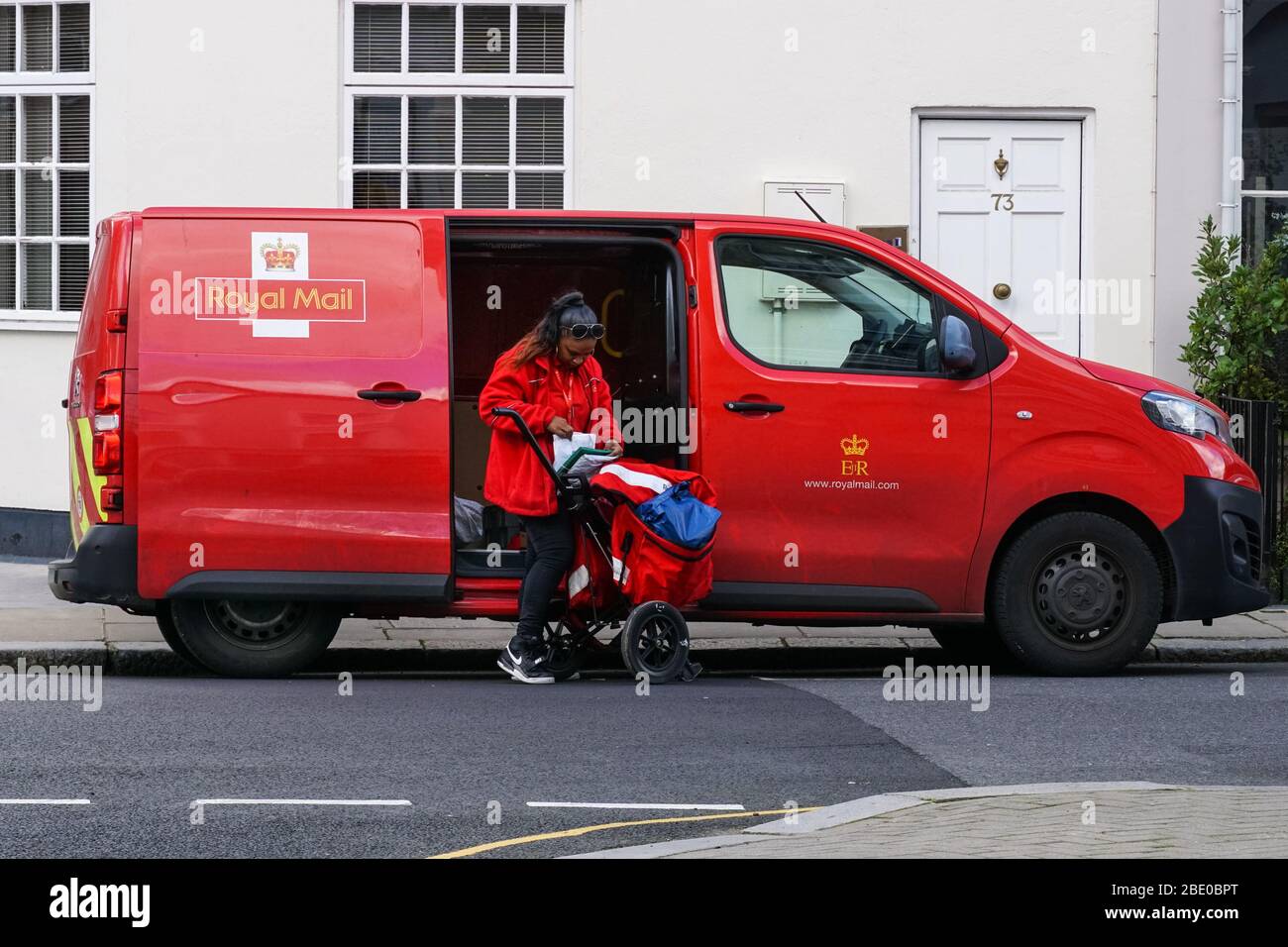 Royal Mail postwoman à côté de Royal Mail van, Londres Angleterre Royaume-Uni Banque D'Images
