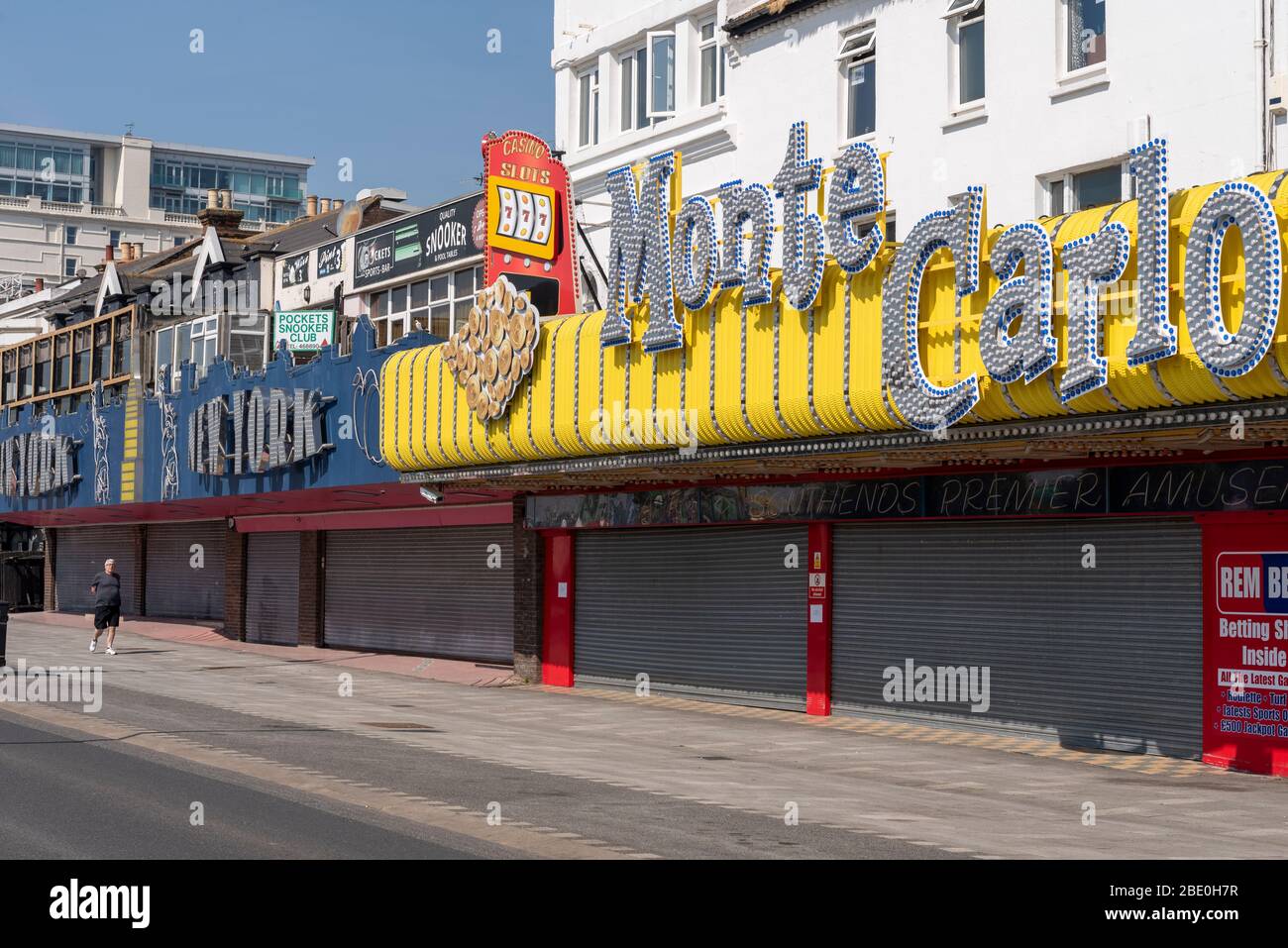 Homme seul passant des entreprises d'arcade fermées, journée ensoleillée sur le front de mer de Southend sur la banque de Pâques vacances pendant la période de verrouillage de la pandémie de Coronavirus COVID-19 Banque D'Images