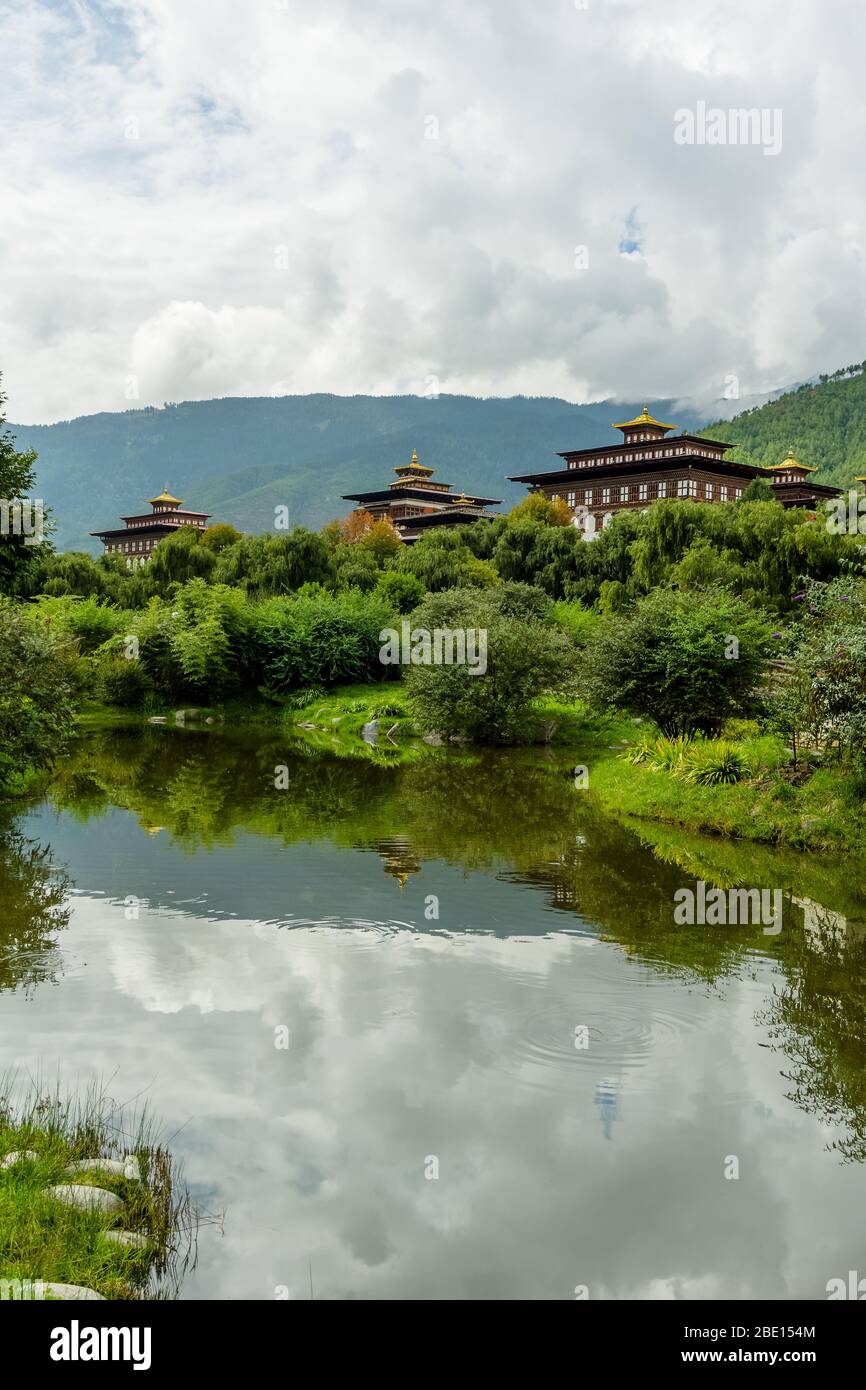 Vue sur Thimphu dzong depuis le parc de Ludrong avec un lac et des fleurs Banque D'Images