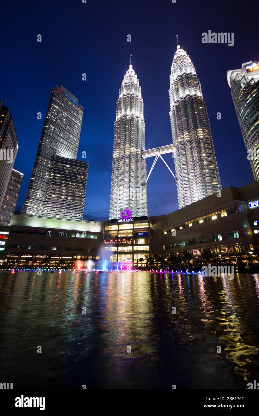 Photo en début de soirée des tours Petronas à Kuala Lumpur, Malaisie avec réflexion dans une petite piscine. Banque D'Images
