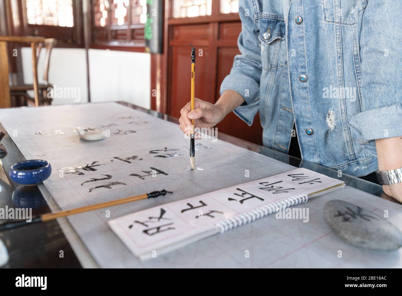 Les voyageurs apprennent à écrire des caractères chinois, la calligraphie est la culture traditionnelle de la Chine Banque D'Images