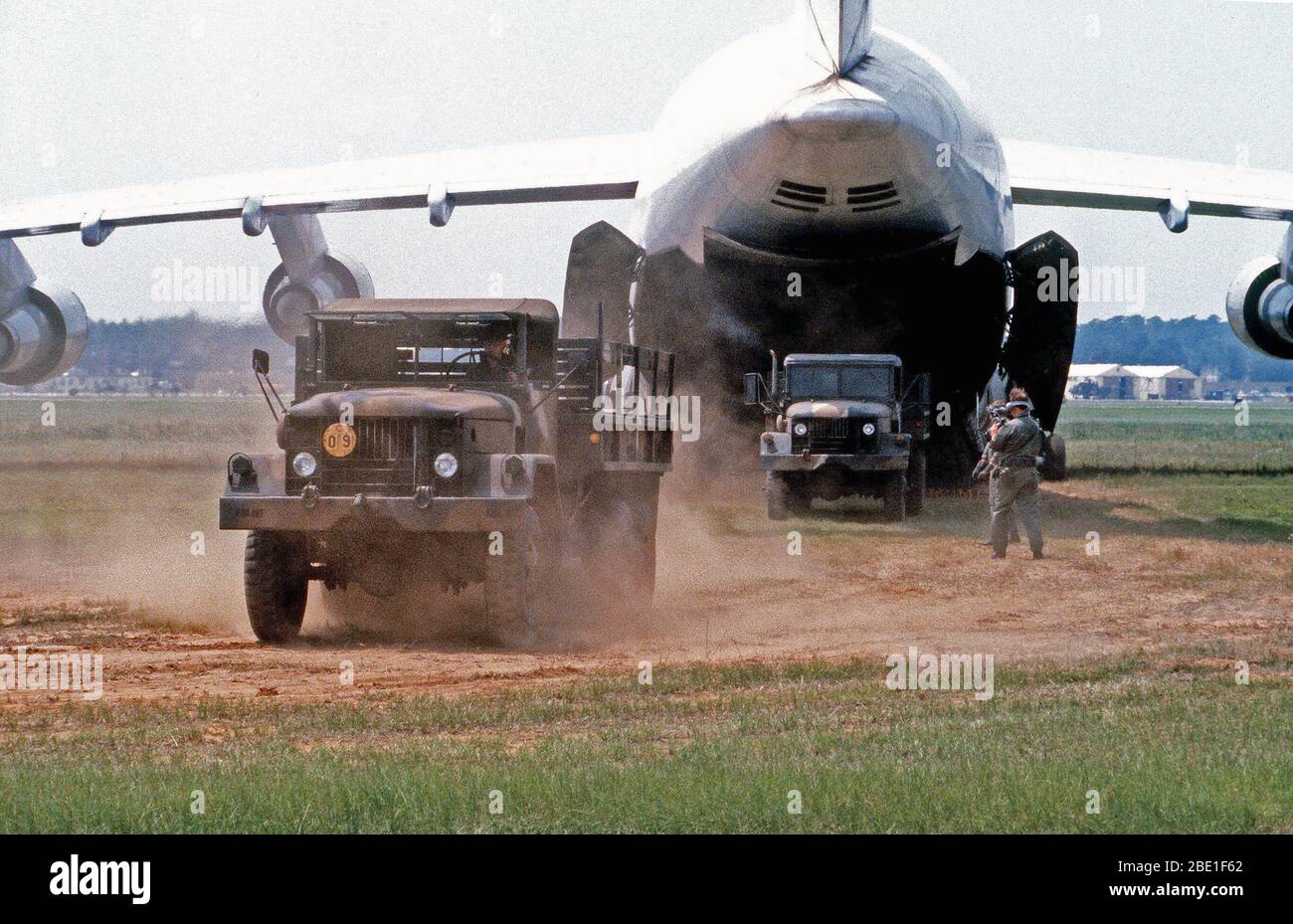 Les camions sont déchargés d'un C-5A Galaxy avion pendant un test d'évaluation de l'utilité opérationnelle. Banque D'Images