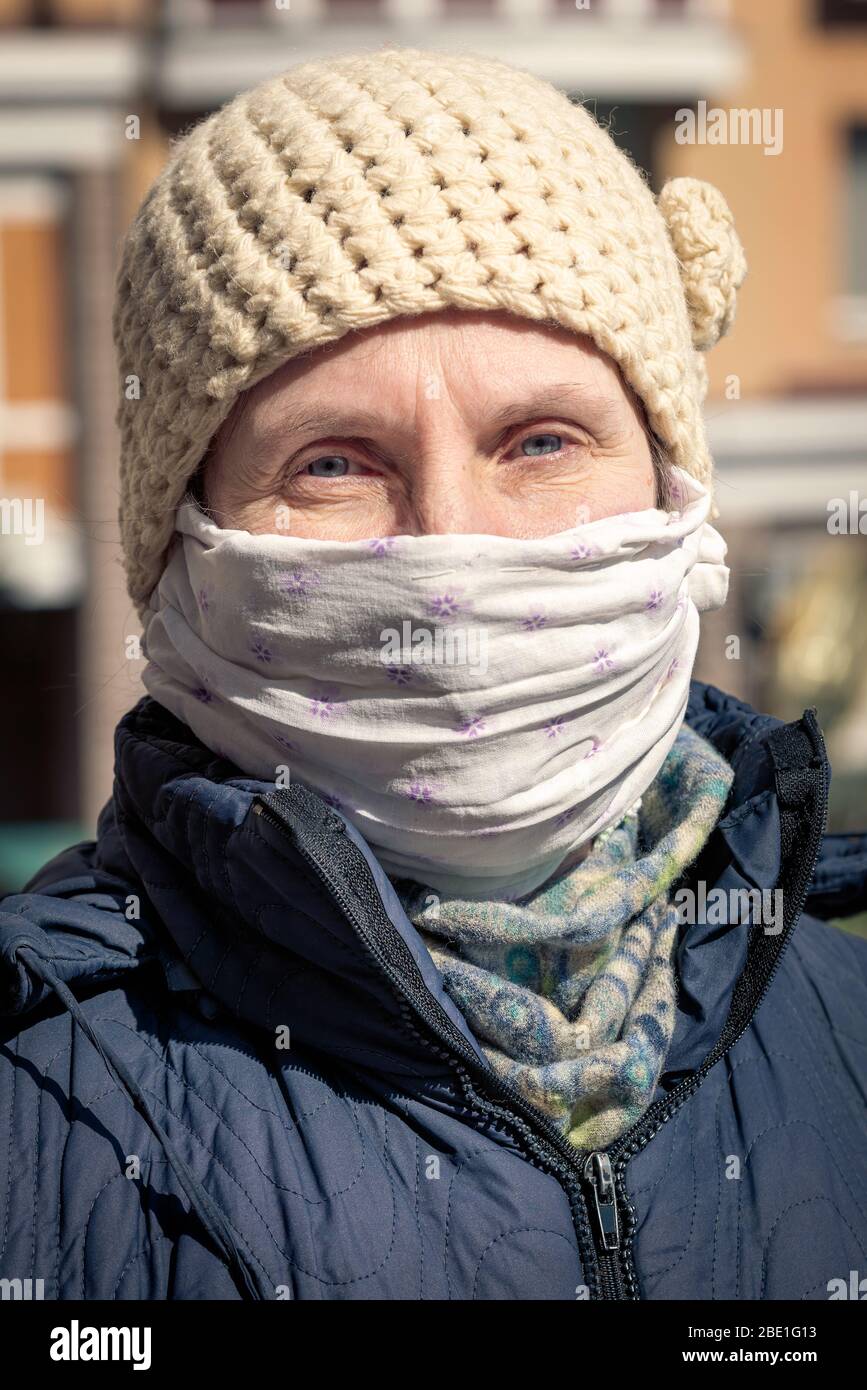 Une femme âgée pauvre porte un masque maison pour se protéger contre des virus tels que le coronavirus, également connu sous le nom de covid-19, ou le SRAS et le MERS. Elle est dans un Banque D'Images