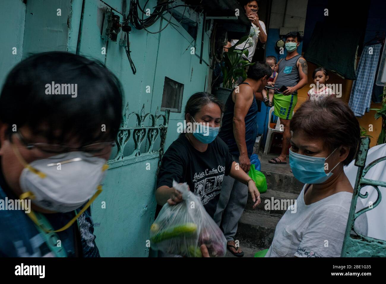 4 avril 2020 - Manille, Philippines: Le capitaine de Barangay DANILO TORRES, à gauche, passe les produits de secours alimentaires à la famille Tablizo à Hangdag Bato ITaaS à Mandaluyong City lors d'un verrouillage de Manille pour freiner la propagation de COVID-19 le 4 avril 2020. Crédit: Eli Hiller/ZUMA Wire/ZUMAPRESS.com/Alamy Live News Banque D'Images