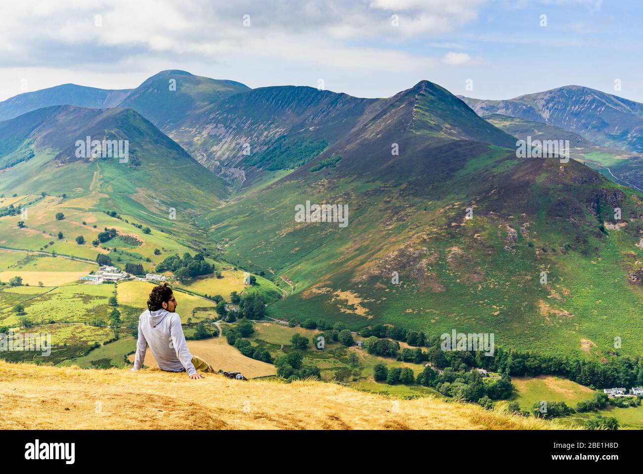 Un randonneur repose sur des cloches dans le district de Lake Anglais qui regarde la vallée de Newlands pour se fauver, y compris Grasmoor Causey Pike et Grisedale Pike Banque D'Images