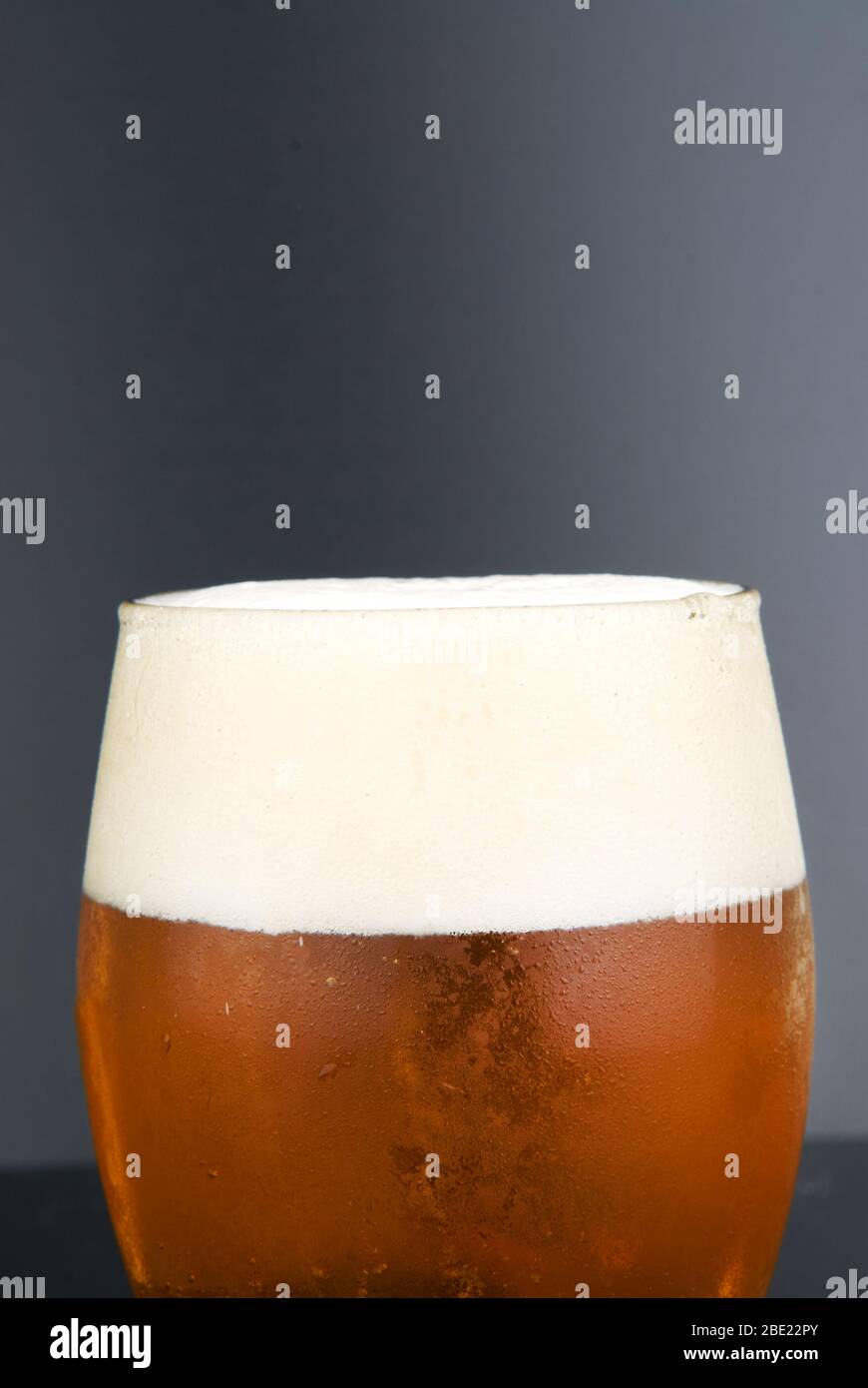 Verre brumeux avec bière froide sur fond noir Banque D'Images