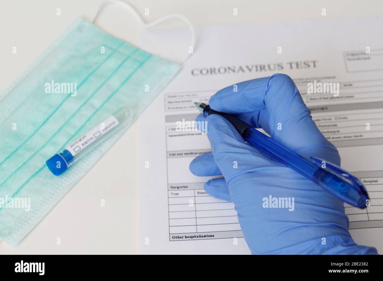 Test de laboratoire pour la détermination du coronavirus. Concept. Le patient remplit le formulaire de consentement pour analyse. Le tube à essai indique POSITIF et NÉGATIF Banque D'Images