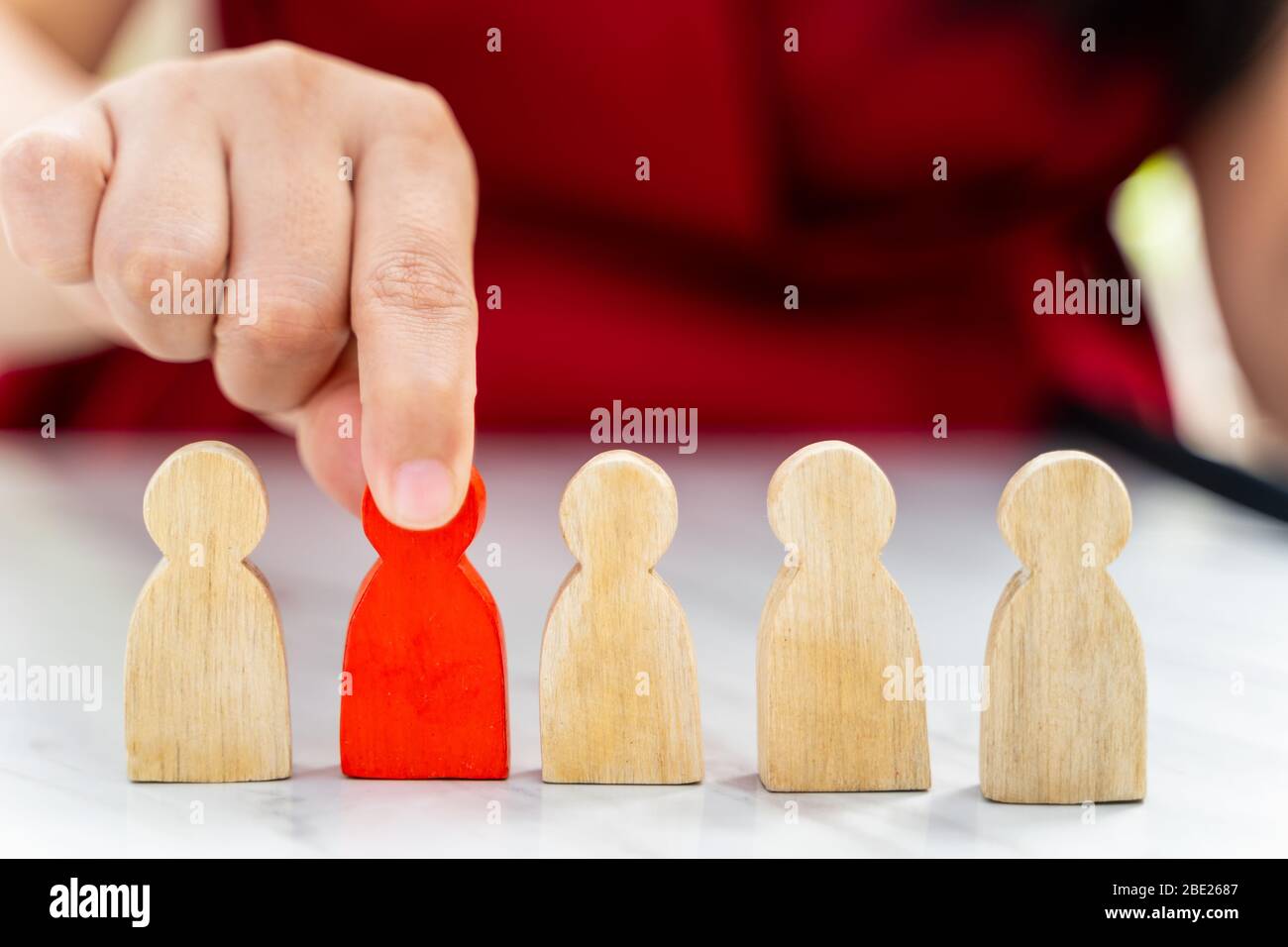 Figure dans le concept de gestion des ressources humaines. Le chiffre en bois rouge a été retiré de son groupe. Figure Red Wood comme qui est sélectionné dans le candidat, Banque D'Images