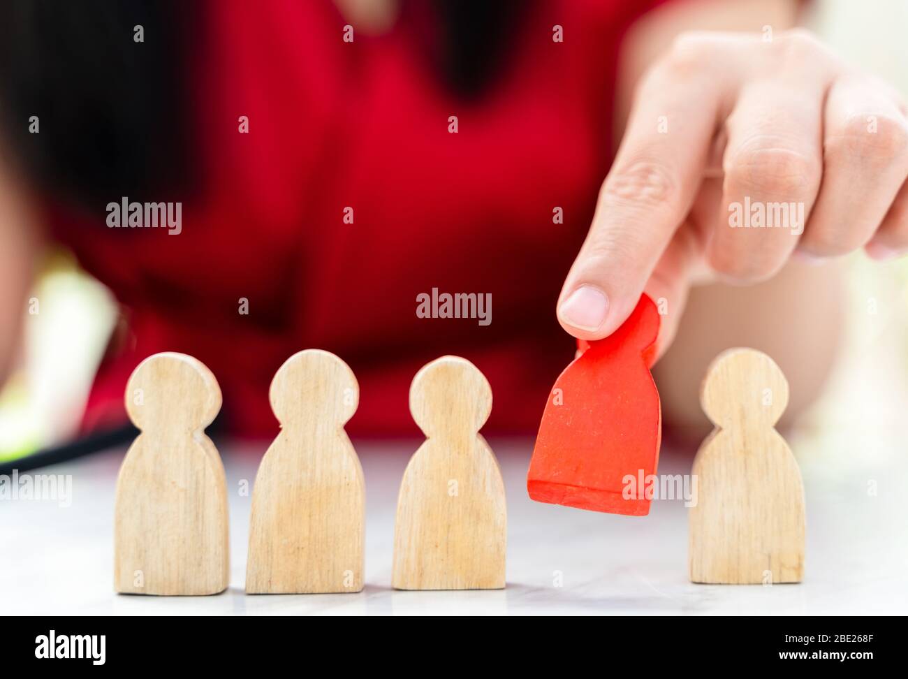 Figure dans le concept de gestion des ressources humaines. Le chiffre en bois rouge a été retiré de son groupe. Figure Red Wood comme qui est sélectionné dans le candidat, Banque D'Images