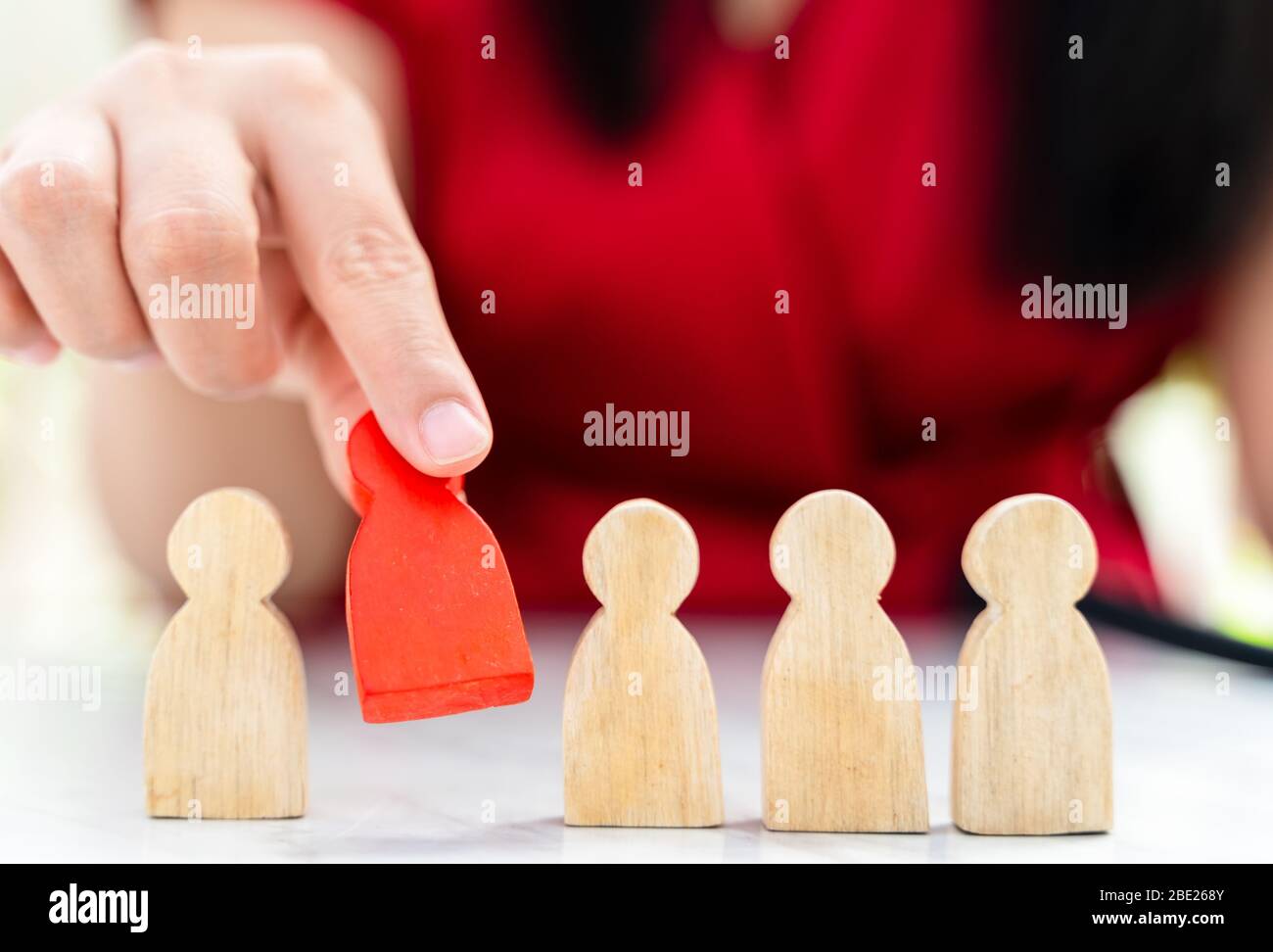 Figure dans le concept de gestion des ressources humaines. Le chiffre en bois rouge a été retiré de son groupe. Figure Red Wood comme qui est sélectionné dans le candidat, Banque D'Images