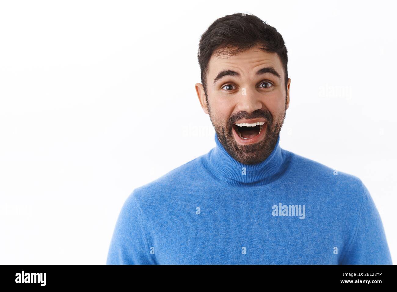 Portrait étroit d'un homme caucasien souriant et enthousiaste avec barbe, à la mode rêveuse et émerveillé par l'appareil photo, contemplant quelque chose de magnifique et Banque D'Images