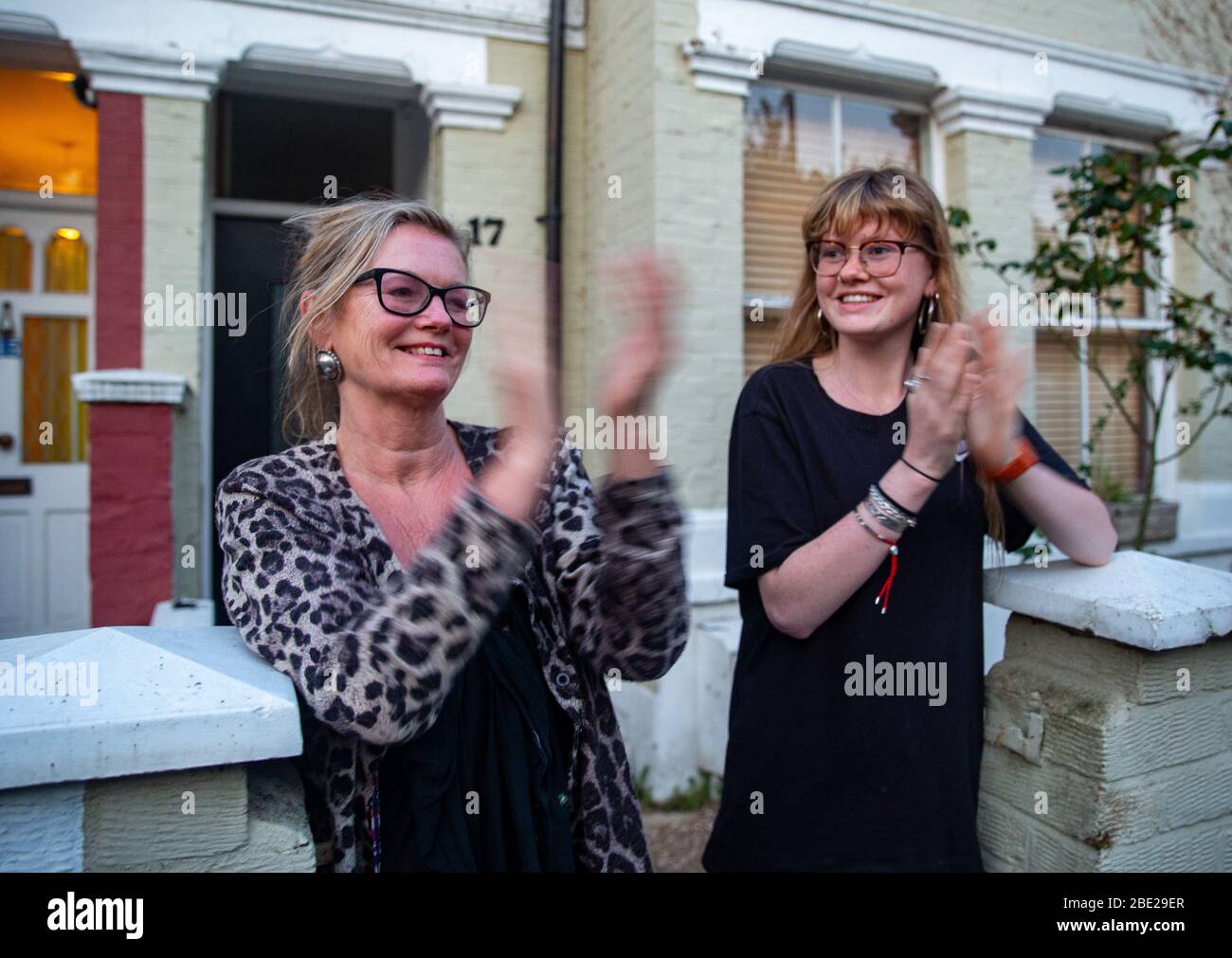 Les gens sortent de leur maison tous les jeudis à 20:00 pour la semaine "Clap pour les soignants". Ils montrent leur soutien aux travailleurs et aux soignants du NHS. Banque D'Images
