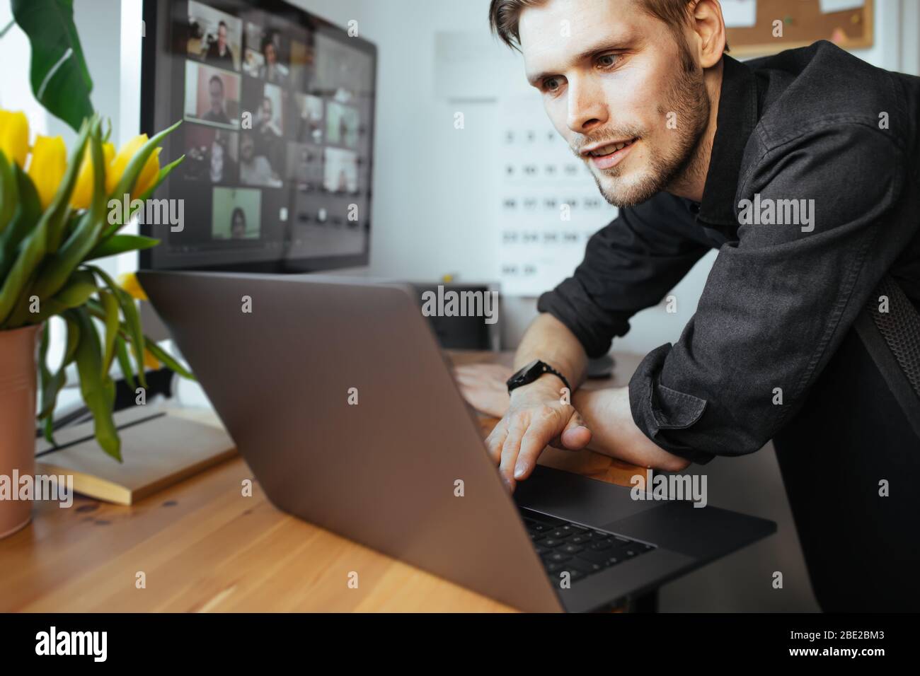 Homme souriant ayant un appel vidéo zoom via un ordinateur portable dans le bureau à domicile. Réunion de conférence à distance avec l'équipe pour le travail. Bureau en ligne Restez à la maison et au travail Banque D'Images
