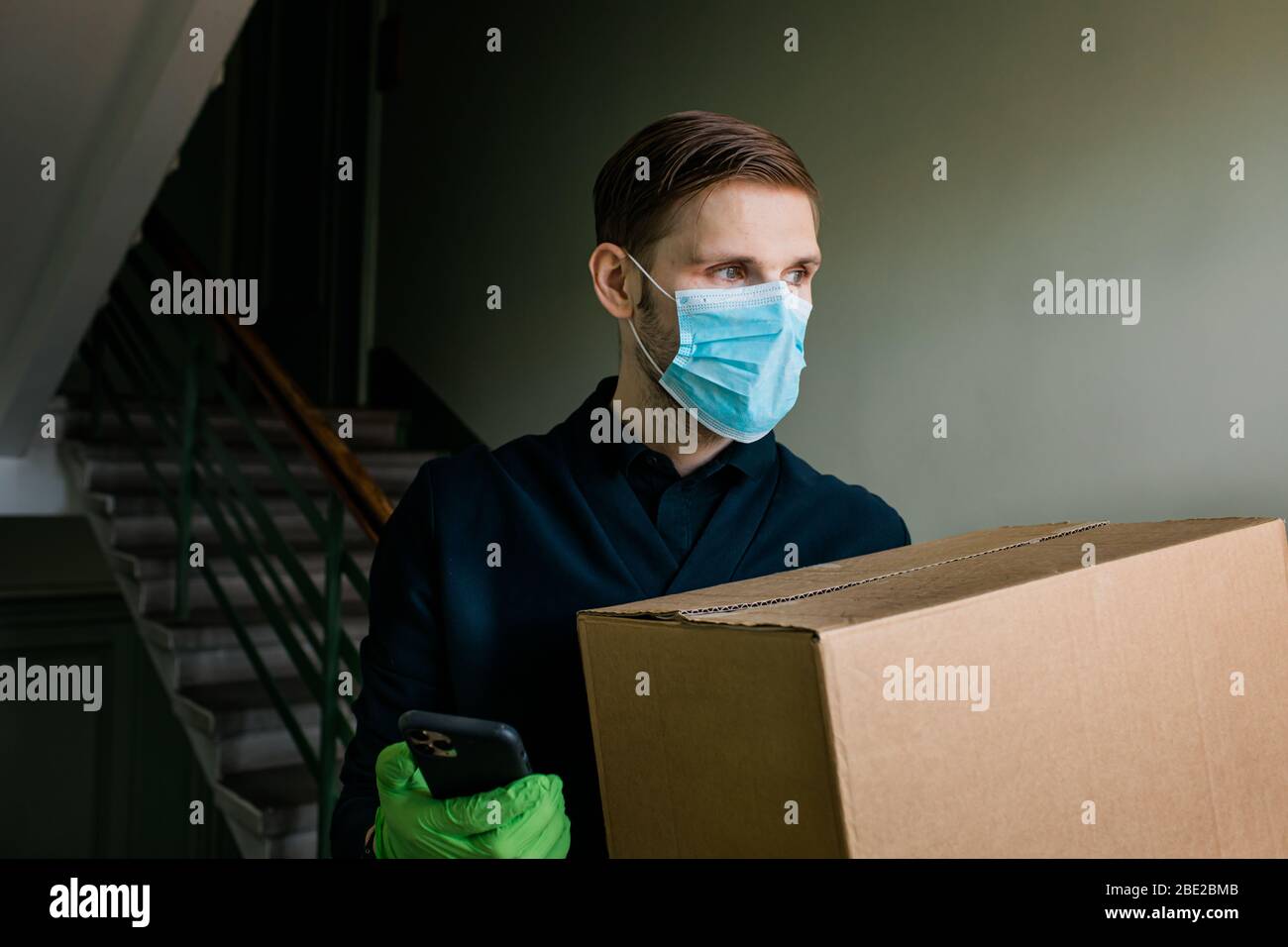 Homme de livraison d'épicerie portant des gants médicaux et un masque facial. Achats et livraison en ligne pour les produits alimentaires, les vins et la nourriture. Auto-quarantaine pendant Covid-19 Banque D'Images