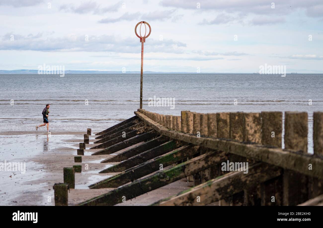 Portobello, Édimbourg. Ecosse, Royaume-Uni. 11 avril 2020. Le week-end de Pâques, le samedi matin, le public faisait des exercices à l'extérieur et marchant sur la plage de Portobello, en dehors d'Édimbourg. La plage et la promenade populaires étaient très calmes et les gens faisaient des exercices de distanciation sociale appropriée. Iain Masterton/Alay Live News Banque D'Images