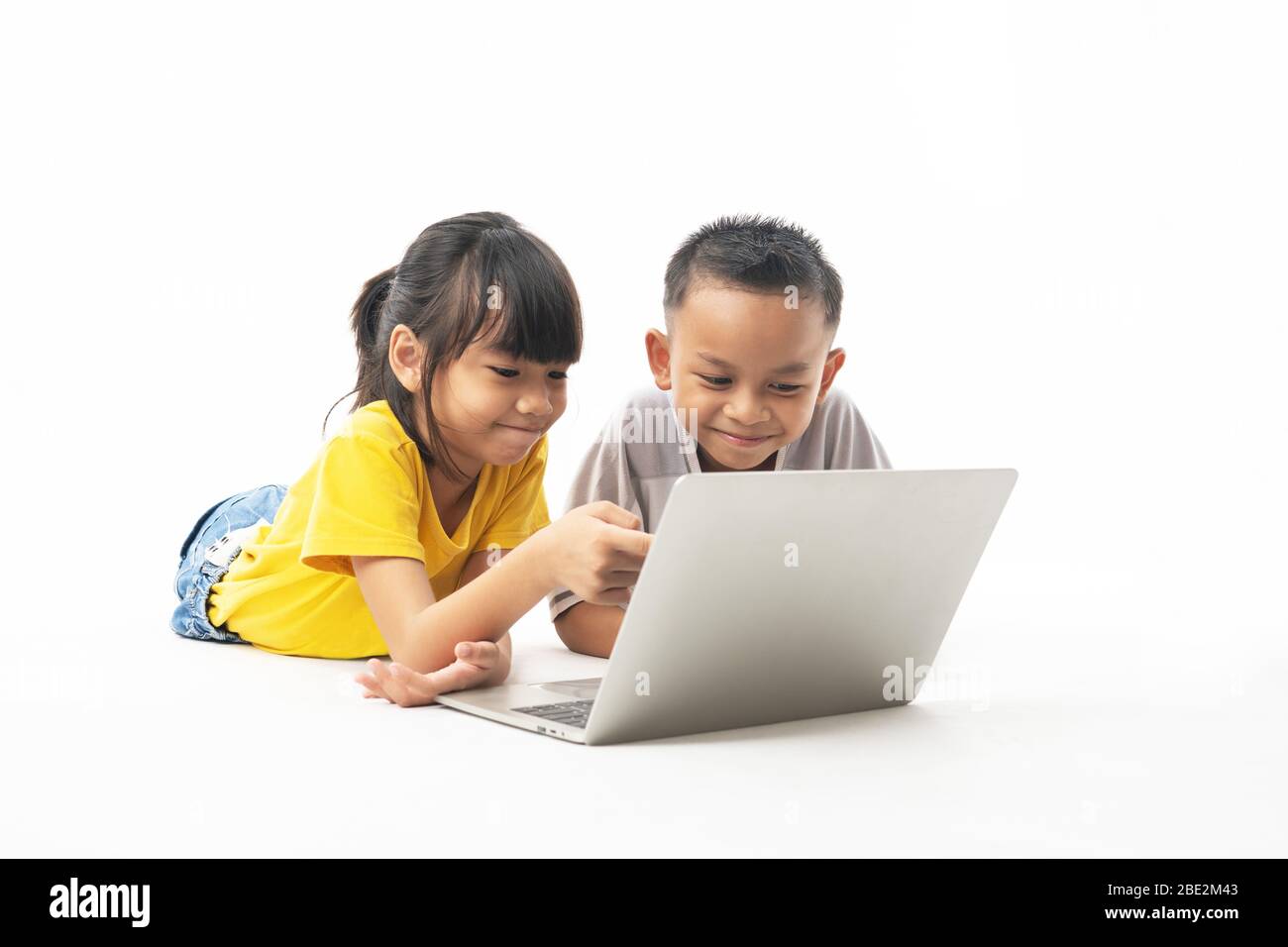 Jeunes enfants, garçons et filles thaïlandais asiatiques pontant et regardant sur ordinateur portable pour apprendre par la technologie et multimédia, isolé et blanc fond Banque D'Images