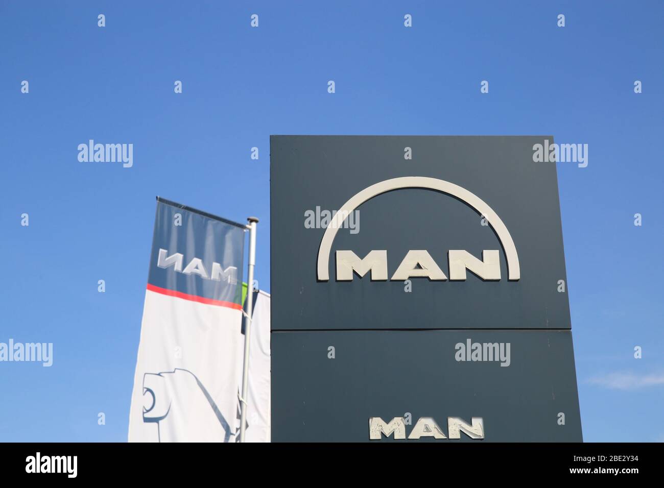 Mönchengladbach, Allemagne - 9 avril. 2020: Gros plan de la colonne avec logo isolé de l'HOMME du constructeur allemand de véhicules commerciaux contre le ciel bleu Banque D'Images