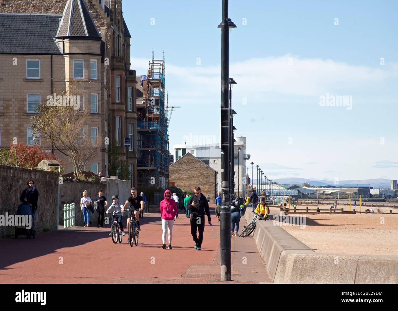 Portobello Promenade, Édimbourg, Écosse, Royaume-Uni. 11 avril 2020. Température de 16 degrés avec plein soleil dans l'après-midi après un début nuageux. Le samedi de Pâques, une plage très calme le troisième week-end de Coronavirus Lockdown. Sur la Promenade, parfois presque autant de cyclistes que de piétons arrivant en groupes de cinq personnes de tous âges, malheureusement pas tous donnent une distance sociale physique comme ils passent, ce qui rend inconfortable est ceux qui marchent le long. Crédit: Arch White/ Alay Live News. Banque D'Images