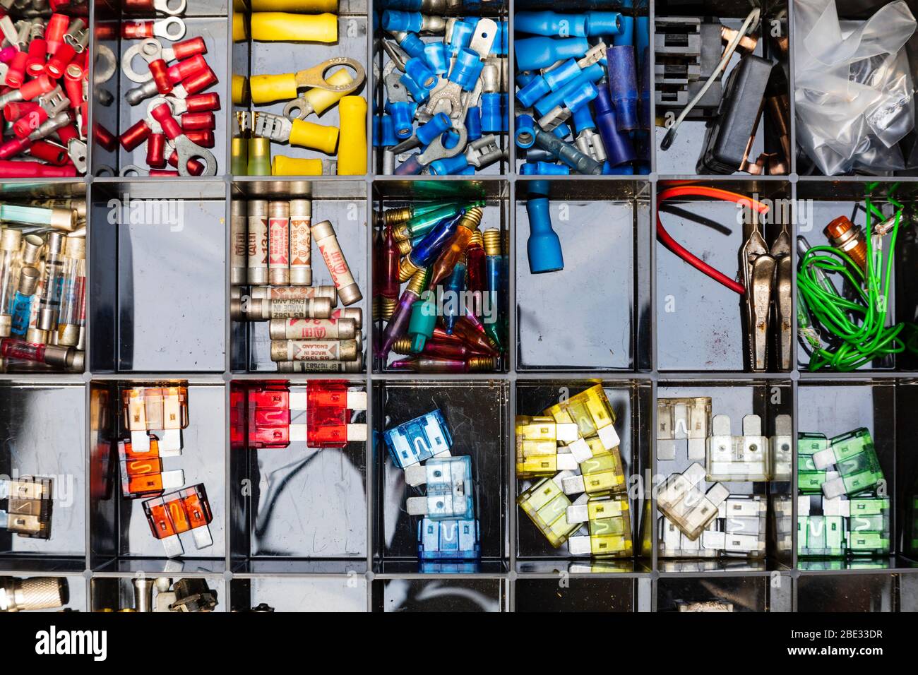 Boîte compartimentée d'électriciens de petites pièces de rechange. Fusibles, connecteurs, ampoules d'éclairage de l'arbre de Noël Banque D'Images
