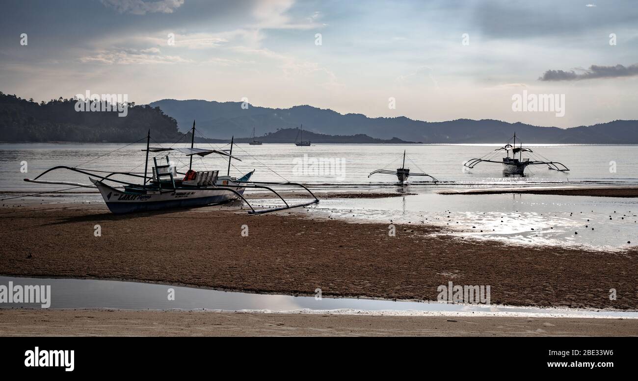 Des bateaux toronnés sur la plage au coucher du soleil Banque D'Images