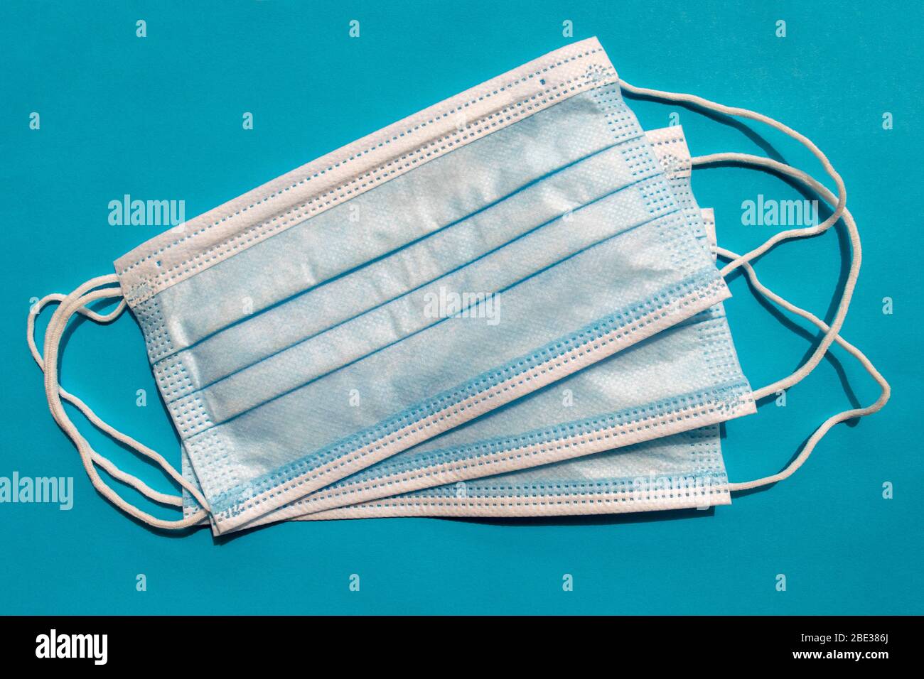 Masques chirurgicaux jetables sur fond bleu. Vue de dessus. Masques médicaux bleus. Bandages respiratoires médicaux comme mesures préventives contre les virus. P Banque D'Images