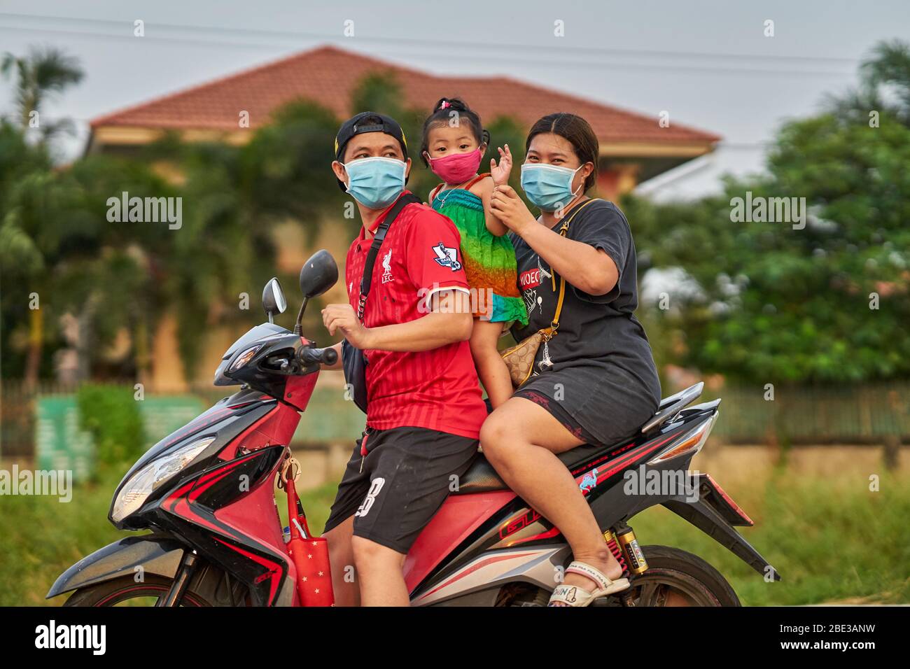 Une famille thaïlandaise voyageant sur une moto, tous portant des masques protecteurs, prise à Pathumthani, Thaïlande, en avril 2020. Banque D'Images