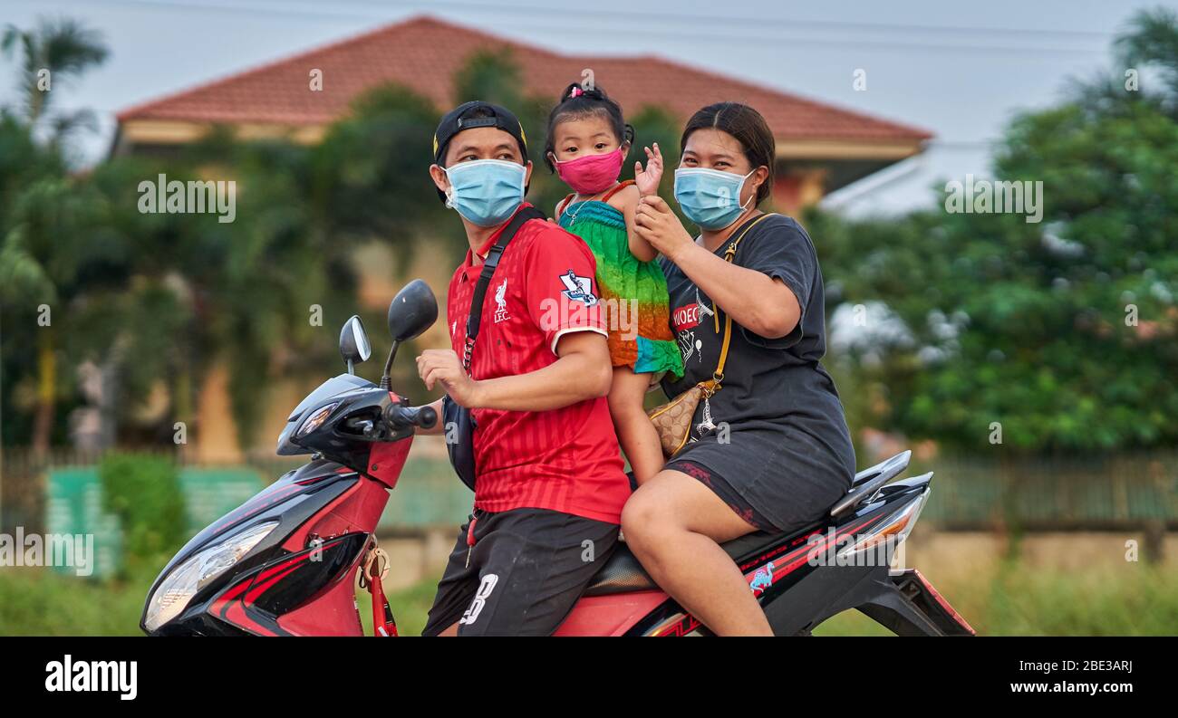 Une famille thaïlandaise voyageant sur une moto, tous portant des masques protecteurs, prise à Pathumthani, Thaïlande, en avril 2020. Banque D'Images