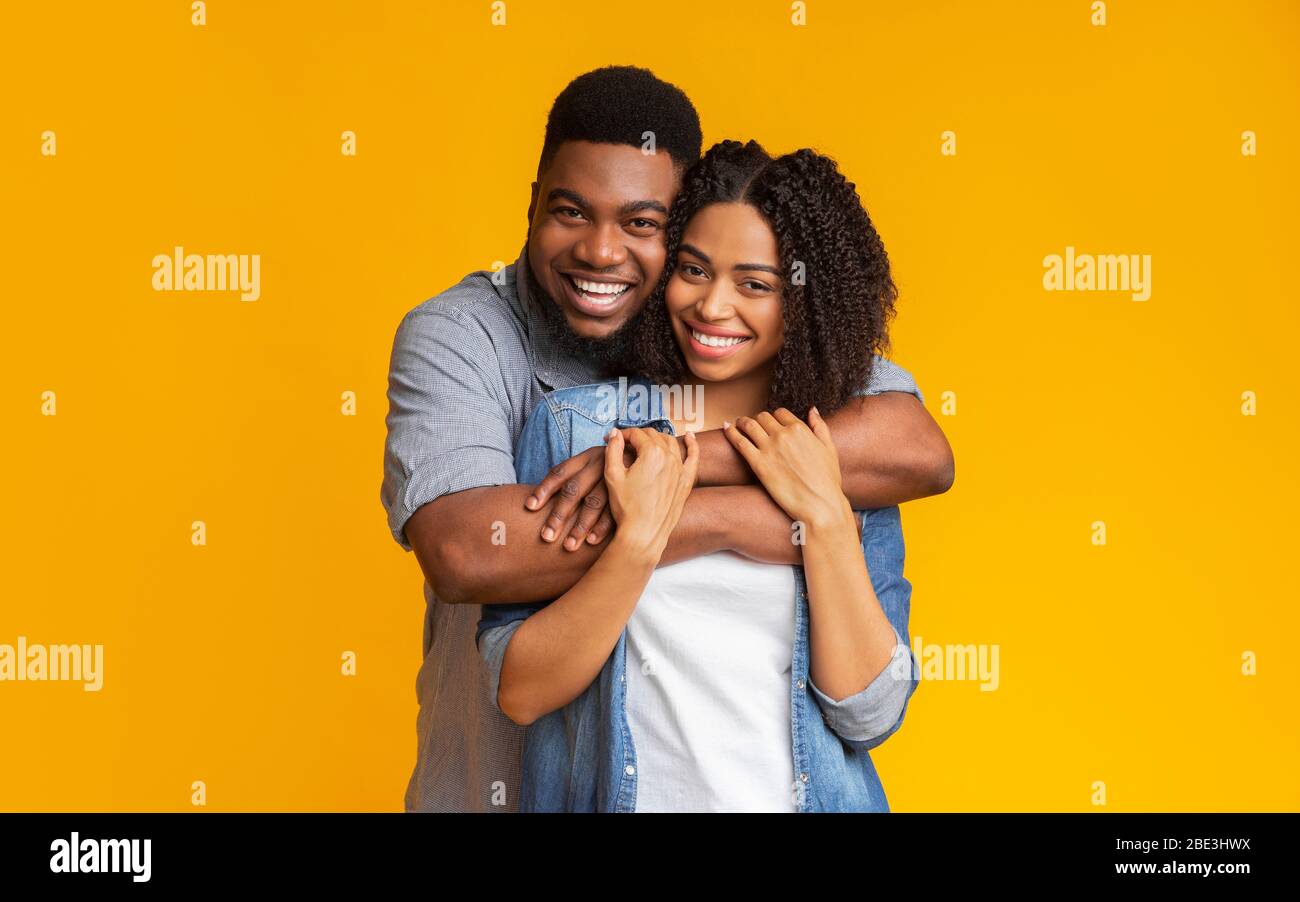 Joyeuses amécœur afro-américain embrassant et posant à l'appareil photo Banque D'Images