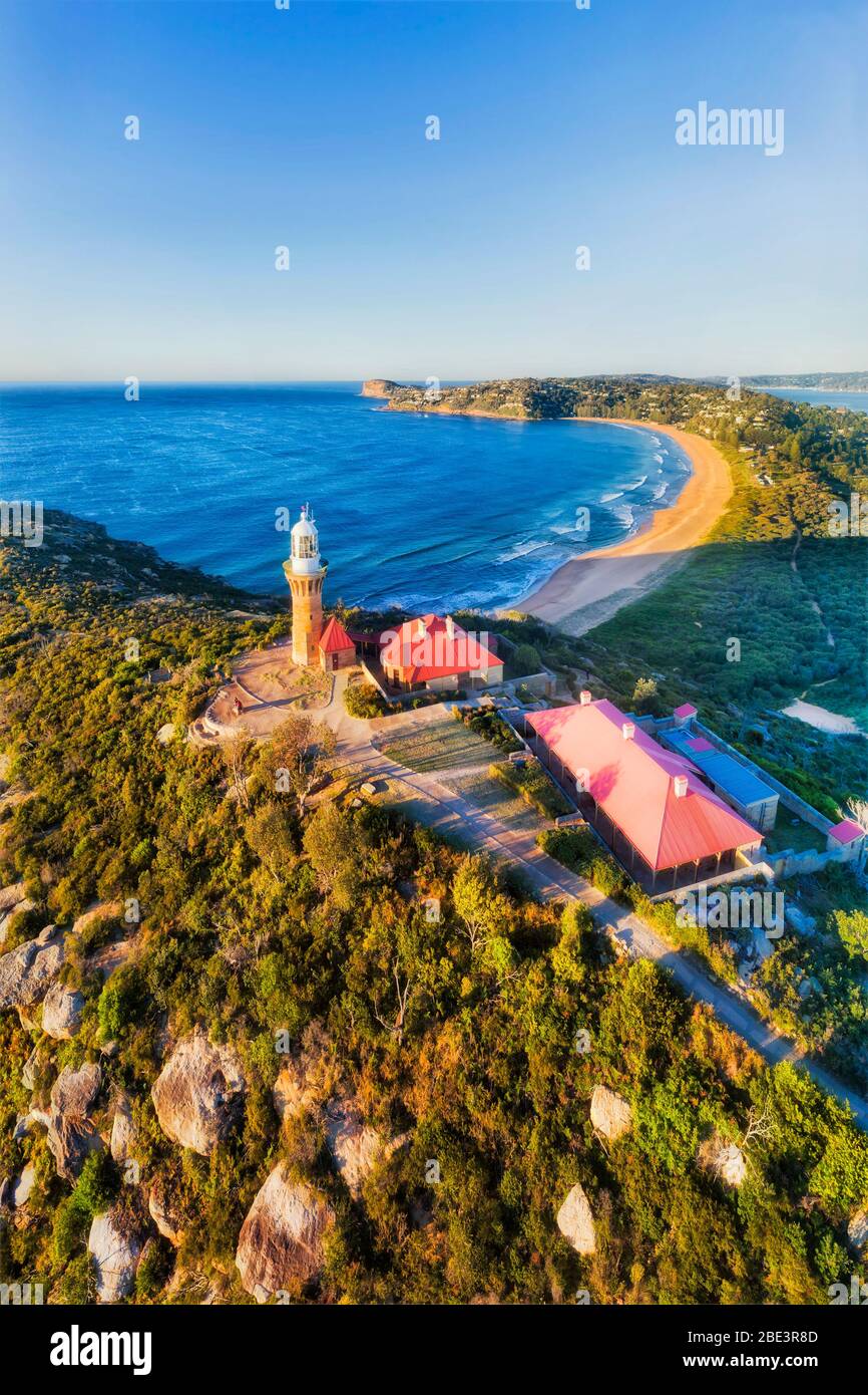 Barrenjoye tête et phare sur son sommet surplombant la plage de Palm Beach sur les plages du nord de Sydney. Panorama vertical aérien. Banque D'Images