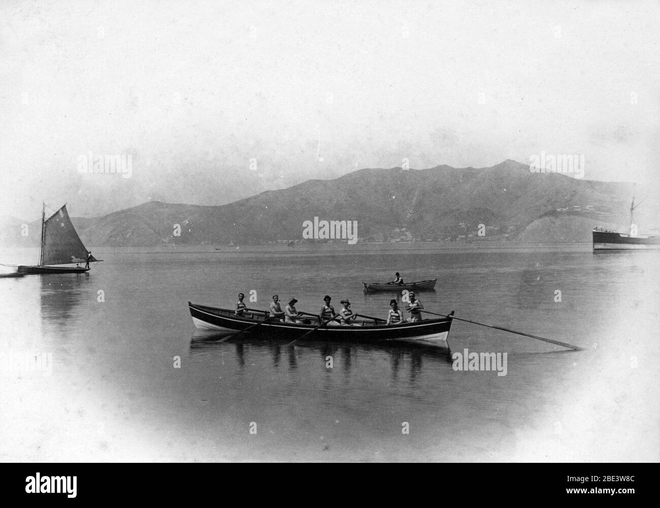 Les hommes s'entrainement pour la compétition dans leur bateau à rames, quelque part dans l'île du Nord de la Nouvelle-Zélande, vers 1915, par le photographe Albert Percy Godber Banque D'Images