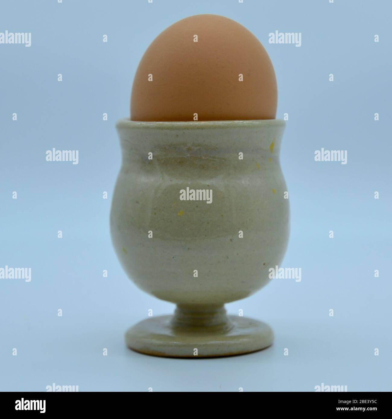 Gros plan d'œufs durs isolés dans une tasse à œufs en faïence sur fond blanc Banque D'Images