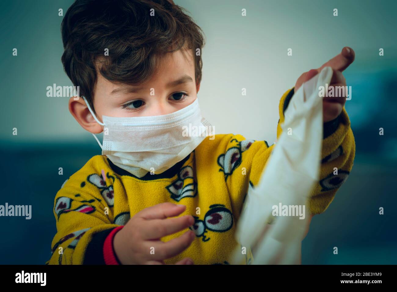 Un Bebe Turc De 3 Ans A L Air Heureux Portant Un Pyjama Et Un Masque Joue Avec Des Gants Chirurgicaux Photo Stock Alamy