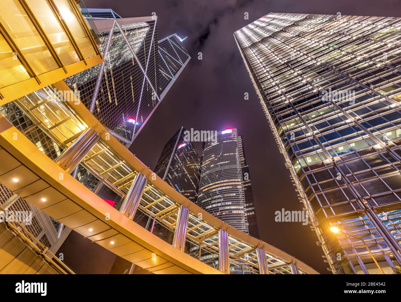 Gratte-ciel et pont en verre et acier style fiction avec réflexions sous le ciel nocturne animé de Hong Kong Banque D'Images