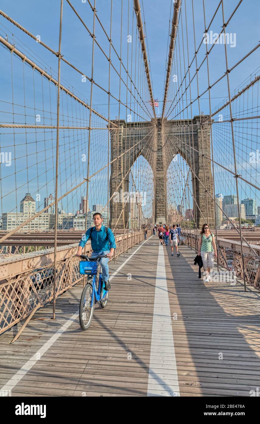 Un cycliste traverse le pont de Brooklyn à New York Banque D'Images