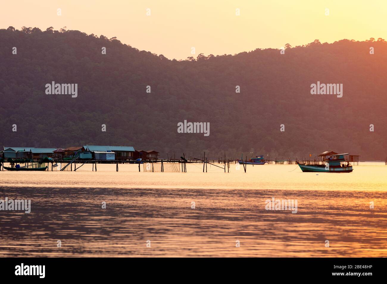 Bateaux et bâtiments sur l'eau pendant un coucher de soleil rose, Starfish Beach; Phu Quoc, province de Kien Giang, Vietnam Banque D'Images