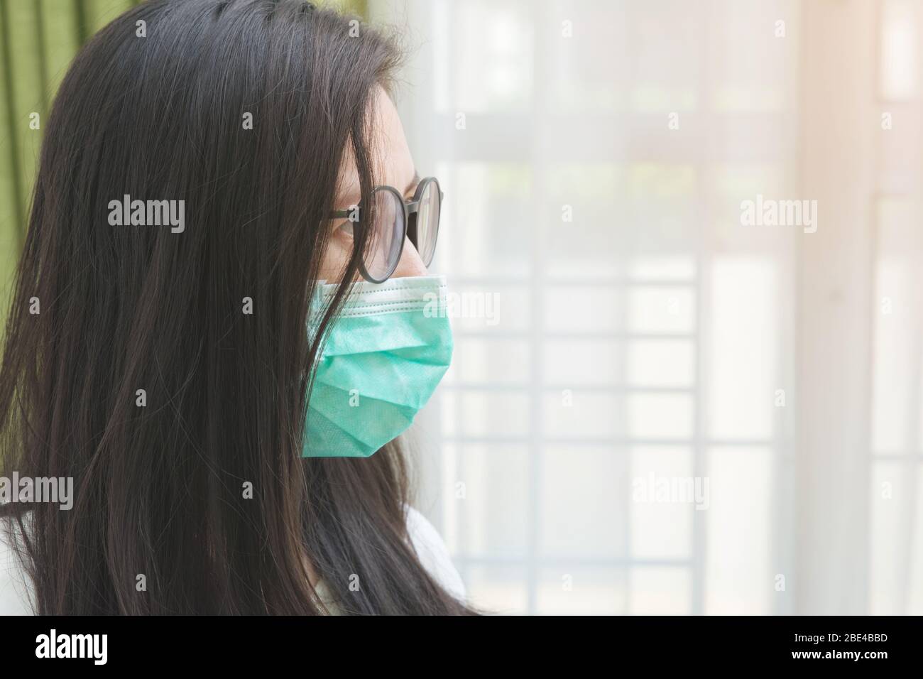 Jeune femme embellisatrice portant un masque vert médecin sur fond blanc. Concept de protection Covid-19. Banque D'Images