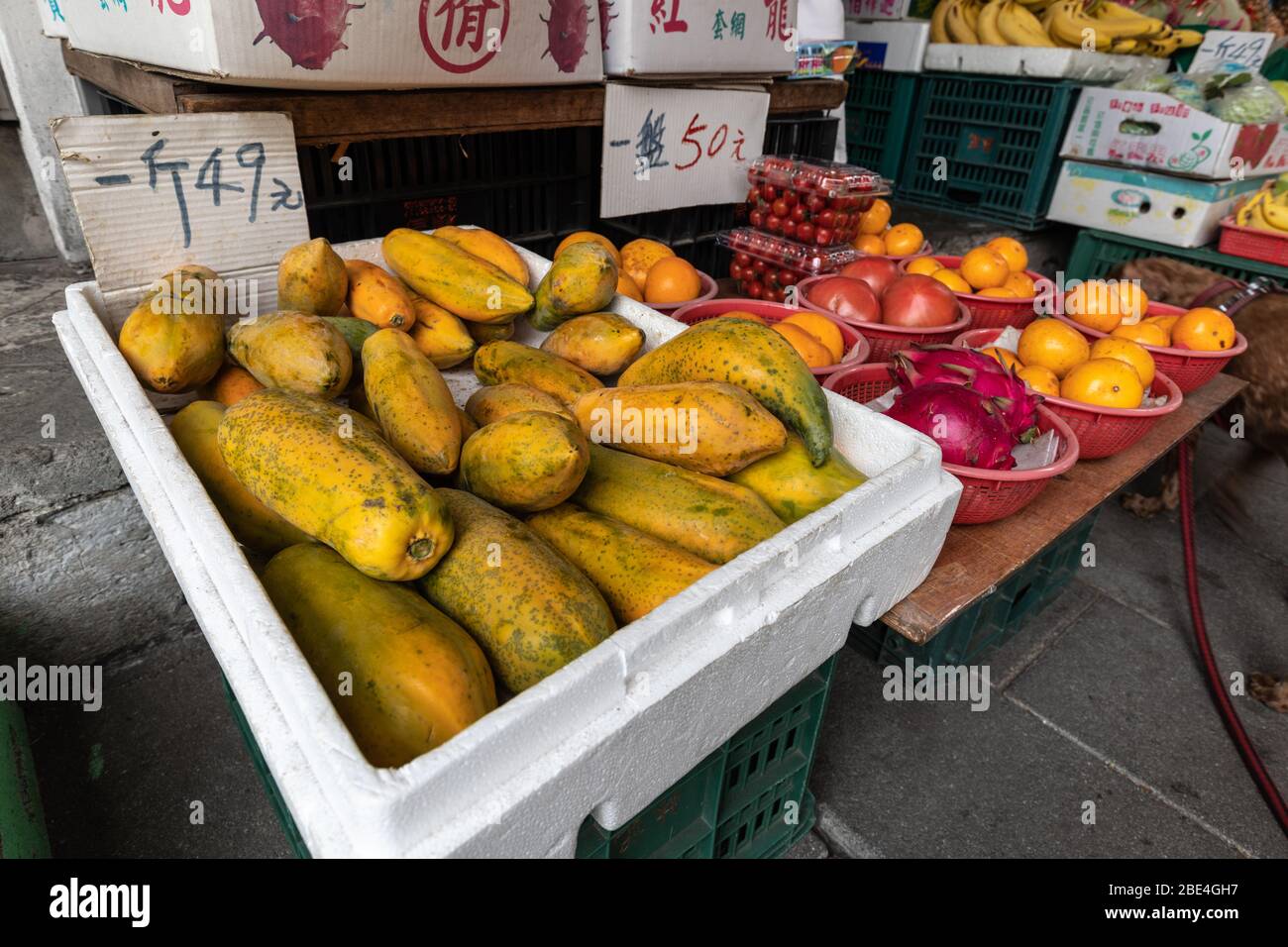Fruits exposés à un vendeur de fruits à Taipei : papaye, persimmons, fruits du dragon, oranges, tomates, tomates cerises, bananes. Banque D'Images