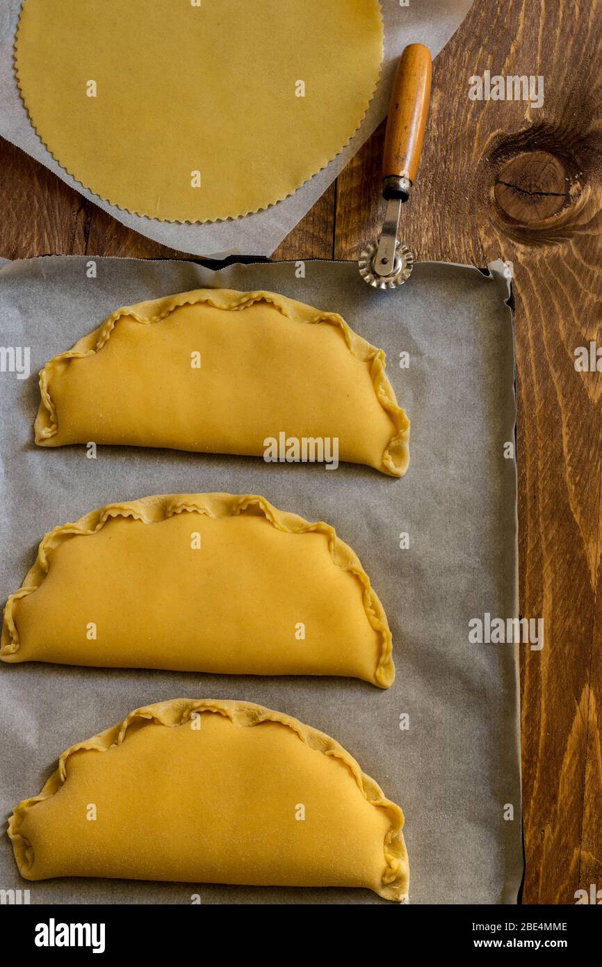 L'image montre la pâte utilisée pour panzerotti remplie de fromage et d'oeuf, un produit typique de la tradition de Pâques de Campanie. Sur fond en bois Banque D'Images