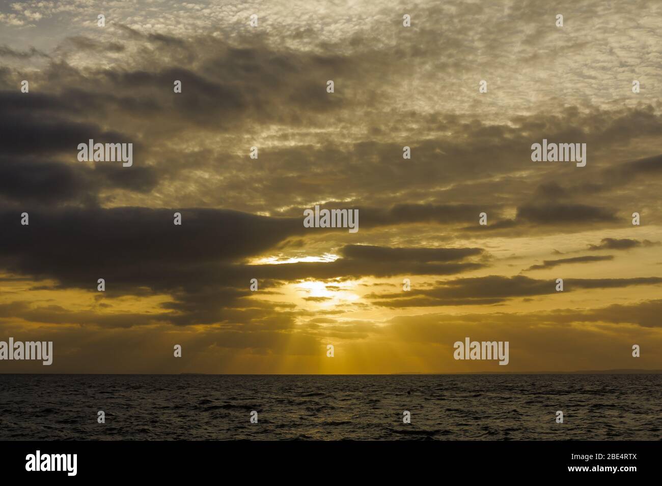 Le soleil sur le point de se coucher sur l'horizon. Banque D'Images