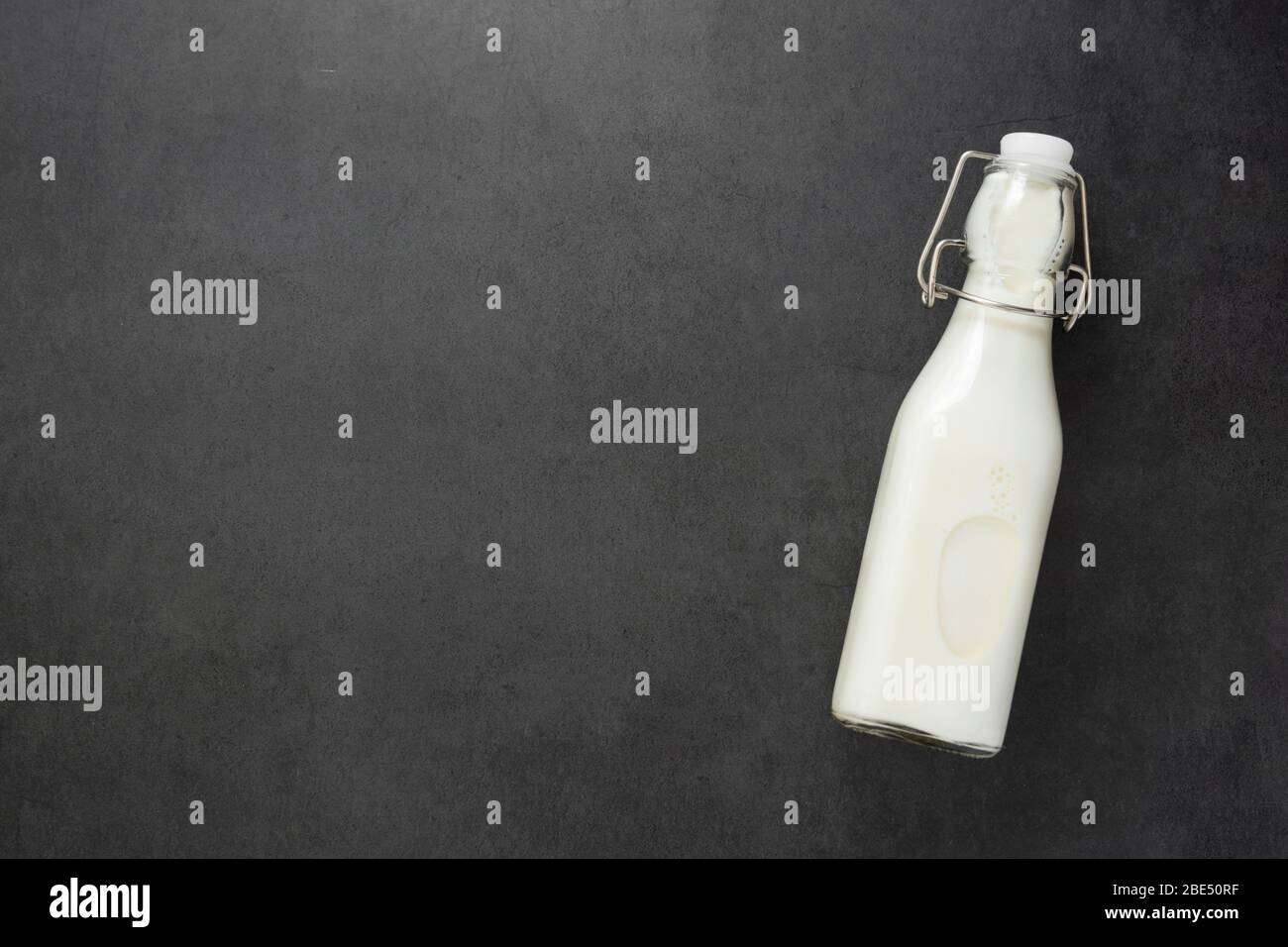 Bouteille de lait isolée sur fond sombre avec espace de copie. Banque D'Images