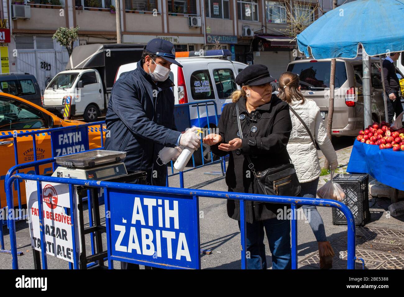 Les officiers donnent des désinfectants aux gens sur le marché de la rue Findikzade, Fatih, Istanbul. Banque D'Images