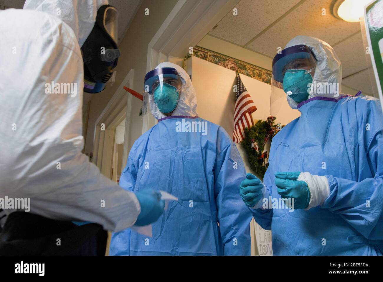 LITTLETON, États-Unis - 03 avril 2020 – les soldats effacent leurs masques de visage avec de l'eau de Javel et de l'eau et retirent leurs gants en latex après avoir administré un COVID-19 Banque D'Images