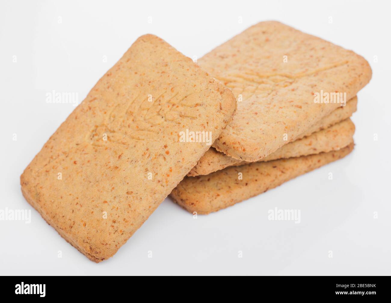 Pile de blé croustillant biologique carré et cinq biscuits salés au grain sur fond blanc. Banque D'Images