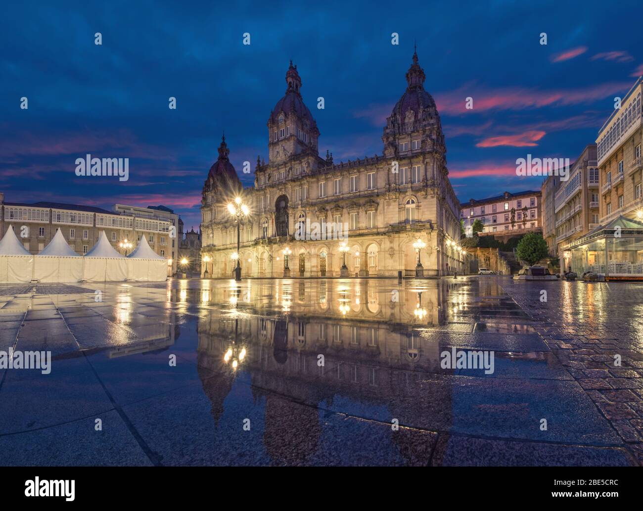 A Coruna, Espagne. Vue sur la place Praza de Maria Pita avec bâtiment de l'Hôtel de Ville reflétant dans la flaque au crépuscule Banque D'Images