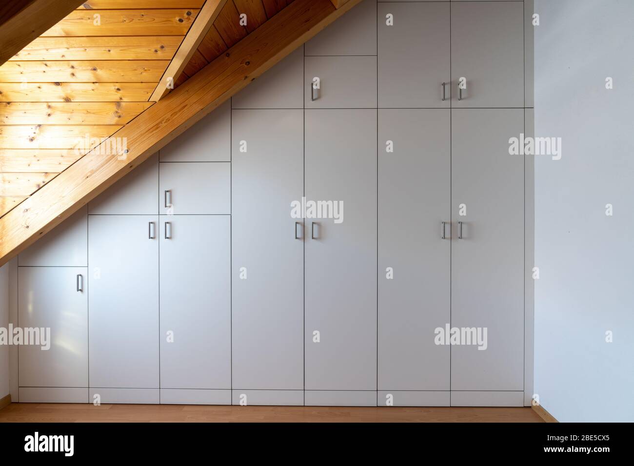 Vue intérieure d'un placard sur mesure intégré dans une chambre principale avec un toit en pente Banque D'Images