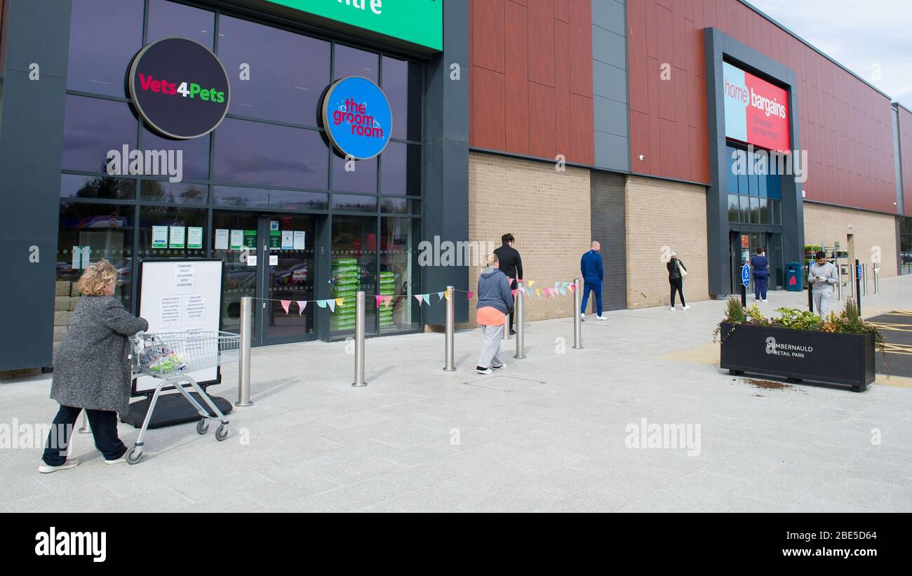 Cumbernauld, Royaume-Uni. 12 avril 2019. Photo : les clients font la queue en dehors d'un magasin de vente à domicile tout en gardant les distances sociales. Scènes pendant le Coronavirus (COVID-19) verrouillage d'un parc de détail à Cumbernauld. Les clients font la queue à l'extérieur pour obtenir leurs gains et fournitures pour la période de fête du dimanche de Pâques. Crédit : Colin Fisher/Alay Live News Banque D'Images